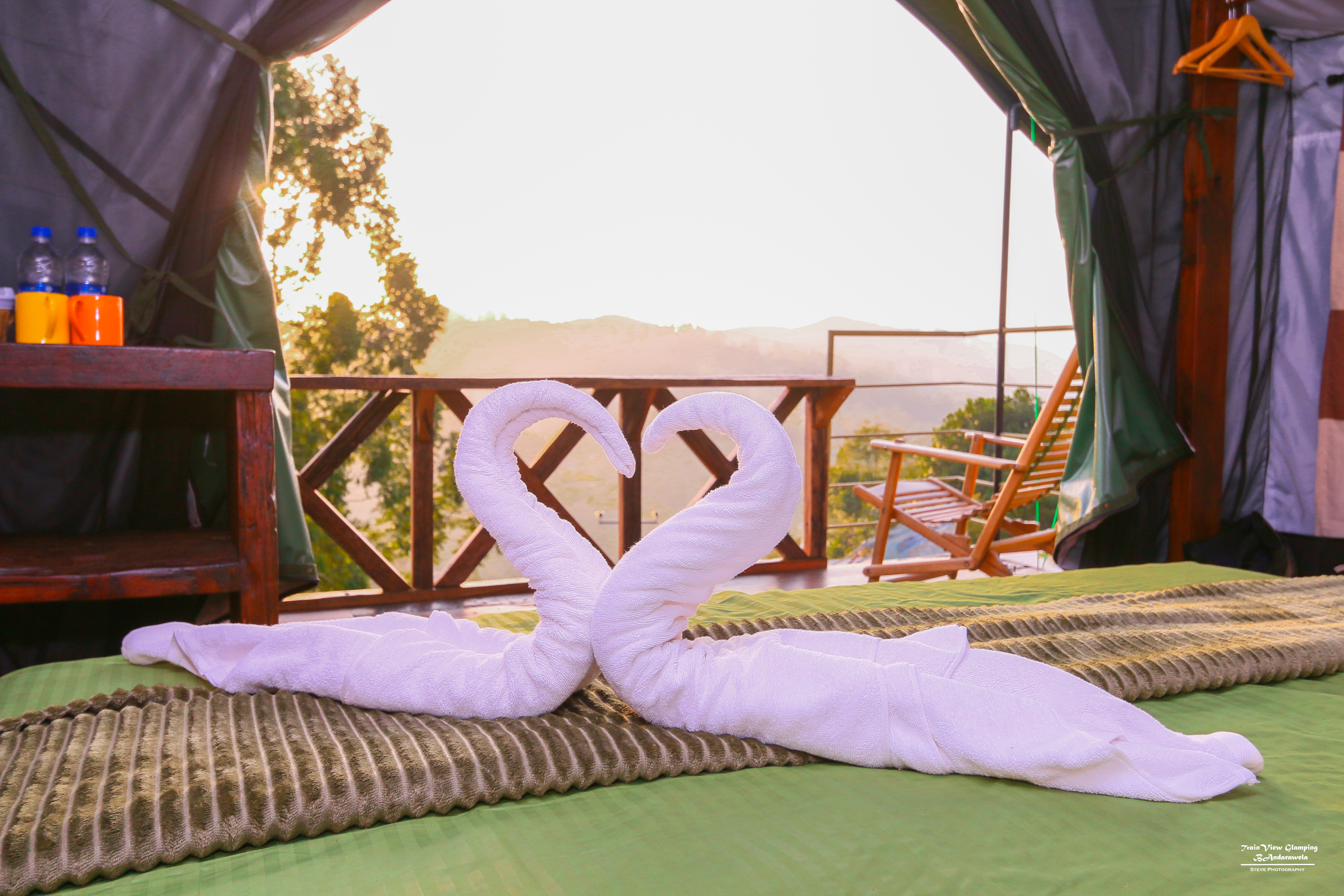 Towel swans arranged on a glamping bed